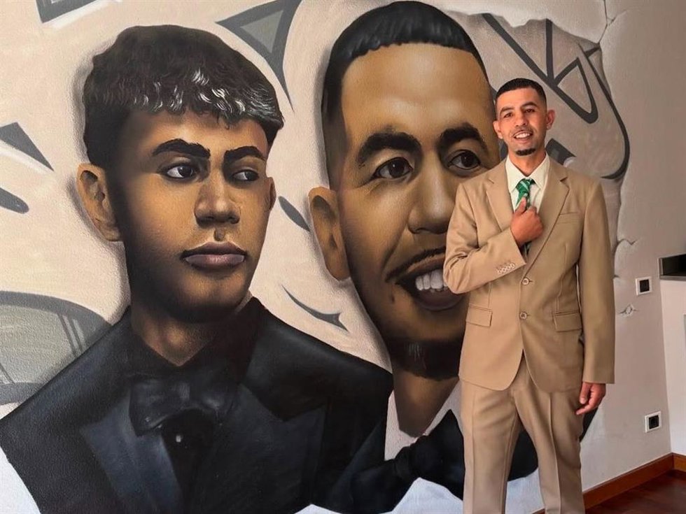 Mounir Nasraoui posando frente al mural que tiene en su casa con una imagen suya y otra de su hijo, Lamine Yamal