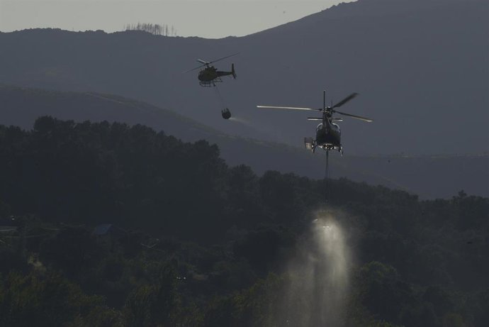 Helicópteros bombardeiros traballan nas tarefas de extinción do incendio forestal de Ribas de Sil, a 12 de xullo de 2026, en Ribas de Sil, Lugo, Galicia (España). O lume, orixinado o sábado pola tarde, continúa sen estar controlado e a superficie a
