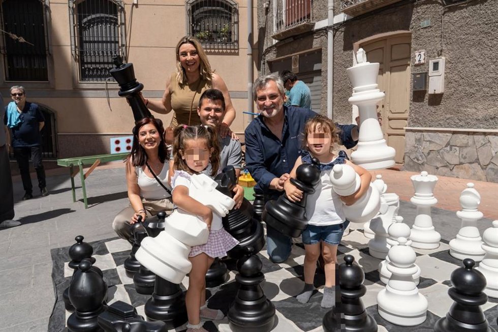Representantes institucionales y menores posan durante una actividad de ajedrez gigante del Plan Corresponsables en Almería.