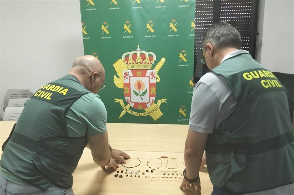 Agentes de la Guardia Civil junto a las joyas robadas