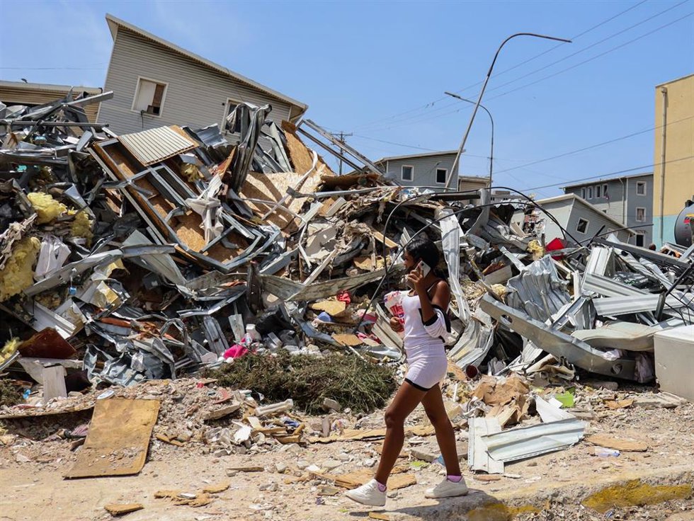 Una mujer camina junto a un edificio derrumbado por causa de los terremotos registrados en Venezuela el 24 de junio. Imagen de archivo
