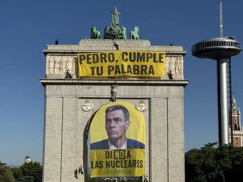 Activistas despliegan una pancarta en el arco de Moncloa