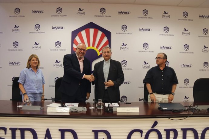 El rector y el deán estrechan sus manos tras la firma del acuerdo.
