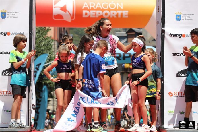 La campeona Leire Fernández rodeada de niños en el podio del Gran Trail Trangoworld Aneto-Posets.