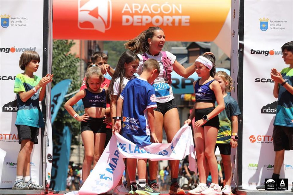 La campeona Leire Fernández rodeada de niños en el podio del Gran Trail Trangoworld Aneto-Posets.