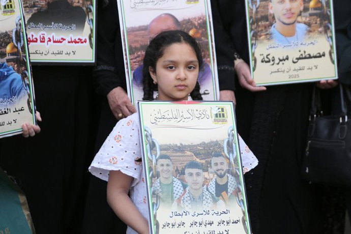 Archivo - Arquivo - 19 de maio de 2026, Nablus, Palestina: Uma menina palestina segura um cartaz com a foto de seus três irmãos presos em prisões israelenses durante uma marcha na cidade de Nablus, na Cisjordânia, em protesto contra a nova lei de pena de 