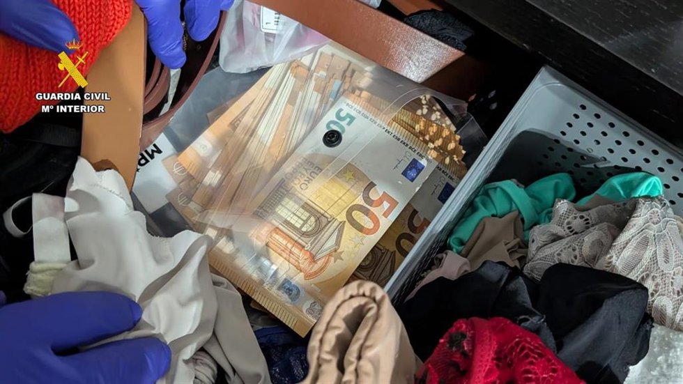 Billetes de 50 euros guardados en una caja de plástico junto a prendas de ropa interior.