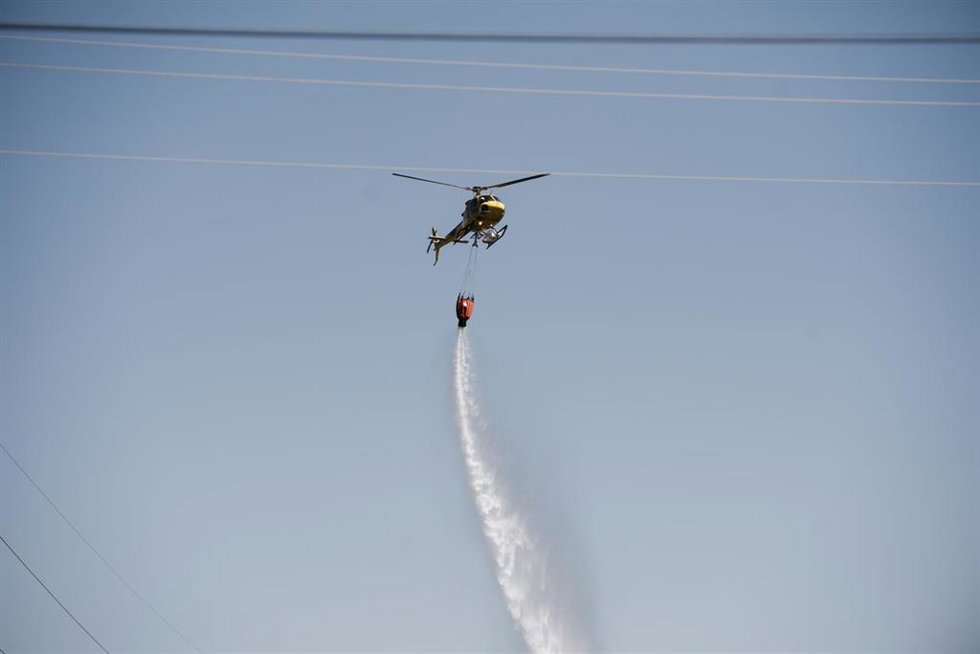 Un helicóptero trabaja en la extinción del incendio, a 17 de julio de 2026, en Lozoyuela, Madrid (España). El servicio de Emergencias del 112 de la Comunidad de Madrid ha informado que continúan los trabajos de los bomberos y de los agentes forestales par