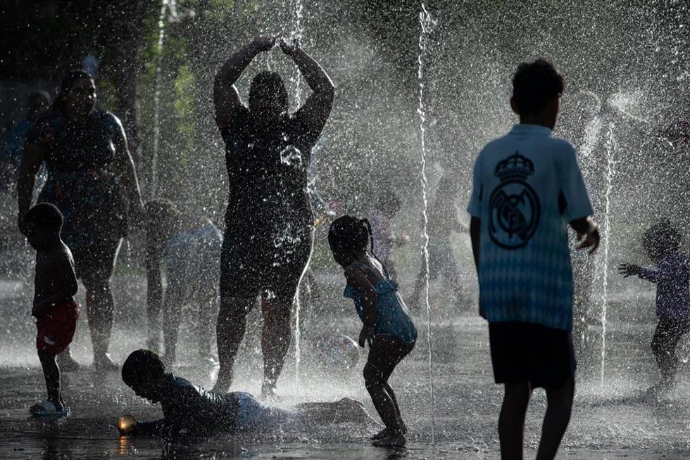 Varias personas se refrescan en las fuentes de Madrid Río, a 23 de junio de 2026, en Madrid (España).