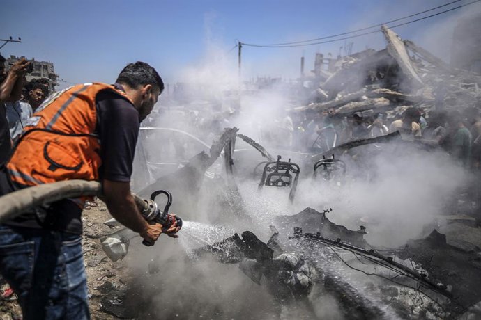 GAZA, July 20, 2026  -- A firefighter extinguishes fire on a burned vehicle following an Israeli drone strike in Gaza City, on July 20, 2026. A drone struck a civilian vehicle in central Gaza City, injuring 14 people, including women and children, a sourc
