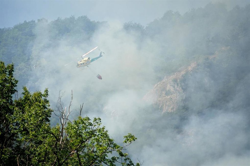 Un helicóptero ayuda en las labores para extinguir el incendio forestal, a 6 de julio de 2026, 