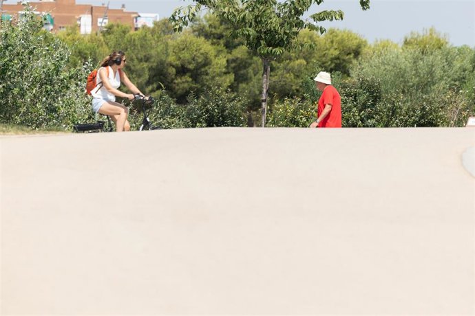 Varias personas pasean en un parque, a 6 de julio de 2026, en Madrid (España). La Agencia Estatal de Meteorología (Aemet) pronostica para este lunes, 6 de julio, el día álgido del episodio de ola de calor que afecta a España, con temperaturas máximas que 
