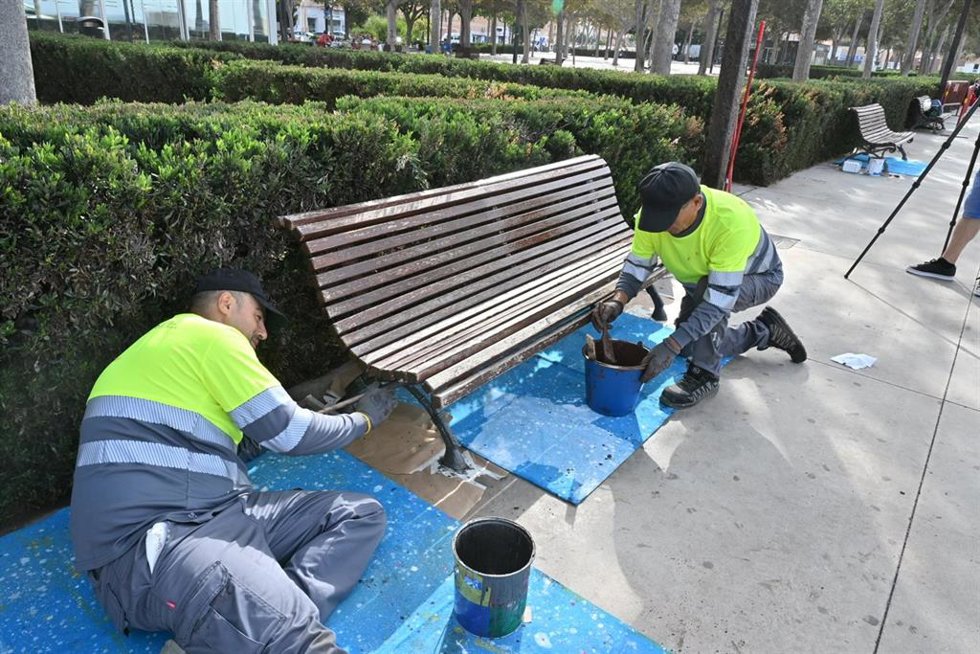 Trabajadores restaurando un banco en un parque. Imagen de archivo