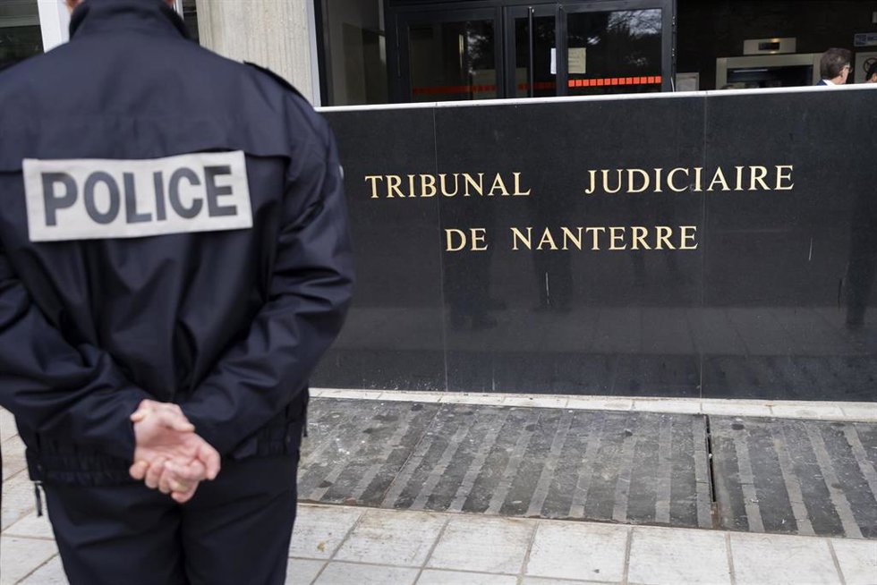 Archivo - Un agente de policía vigila la entrada del juzgado de Nanterre.