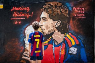 Un niño observa el mural de Ferran Torres del artista urbano Tvboy, a 21 de julio de 2026, en Barcelona, Catalunya (España). El reconocido artista urbano ha dedicado esta creación en Barcelona a Ferran Torres, en homenaje al gol que marcó en la Final del 