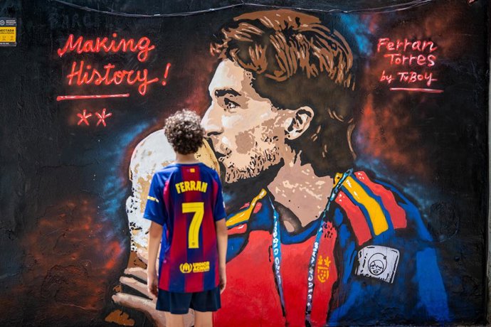 Un niño observa el mural de Ferran Torres del artista urbano Tvboy, a 21 de julio de 2026, en Barcelona, Catalunya (España). El reconocido artista urbano ha dedicado esta creación en Barcelona a Ferran Torres, en homenaje al gol que marcó en la Final del 
