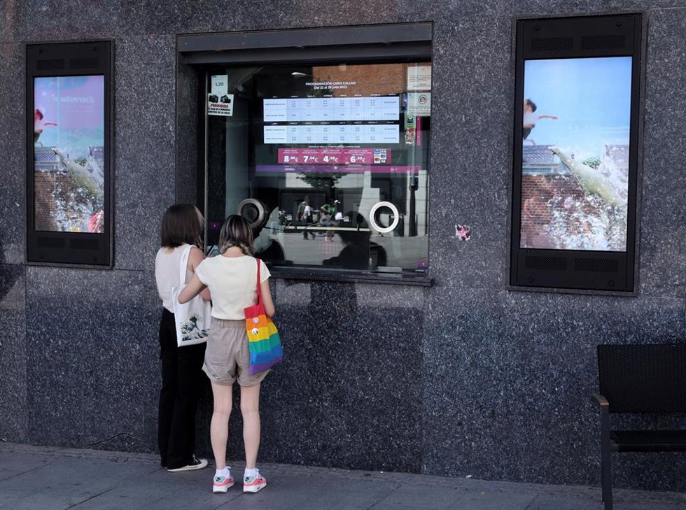Archivo - Dos personas en la taquilla de los cines Callao