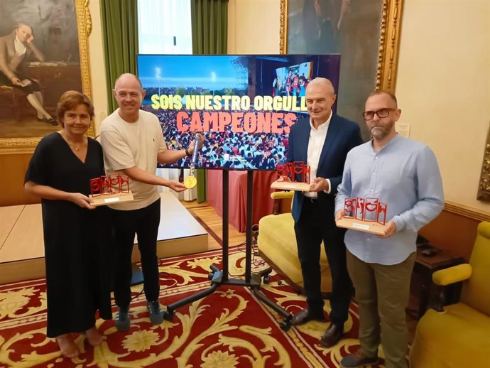 La alcaldesa gijonesa, Carmen Moriyón, recibe al segundo entrenador de la Selección Española, Juanjo González, al médico, Óscar Celada, y al cámara de la Federación Española y miembro de la expedición en el Mundial, Borja Medio.