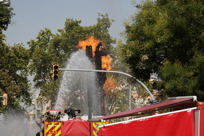 Els bombers ruixant aigua sobre la flama