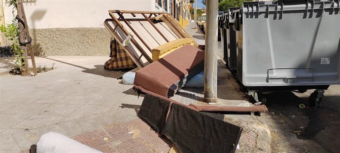 Muebles abandonados junto a contendores de la basura en Huelva.