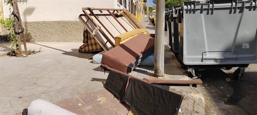 Muebles abandonados junto a contendores de la basura en Huelva.