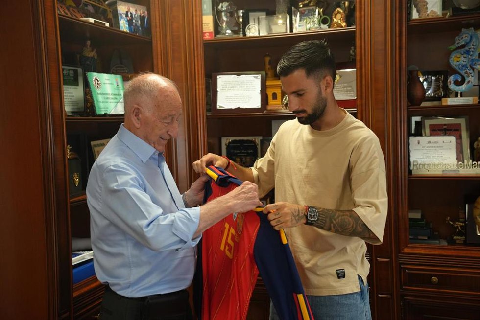 El alcalde de Roquetas de Mar, Gabriel Amat, recibe de Álex Baena una camiseta de la selección española durante la visita del futbolista al Ayuntamiento.
