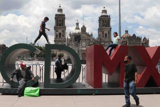 Archivo - 14 August 2021, Mexico, Mexico City: People sit on an installation reading "CDMX" (Mexico City) at Zocalo Plaza in Mexico City