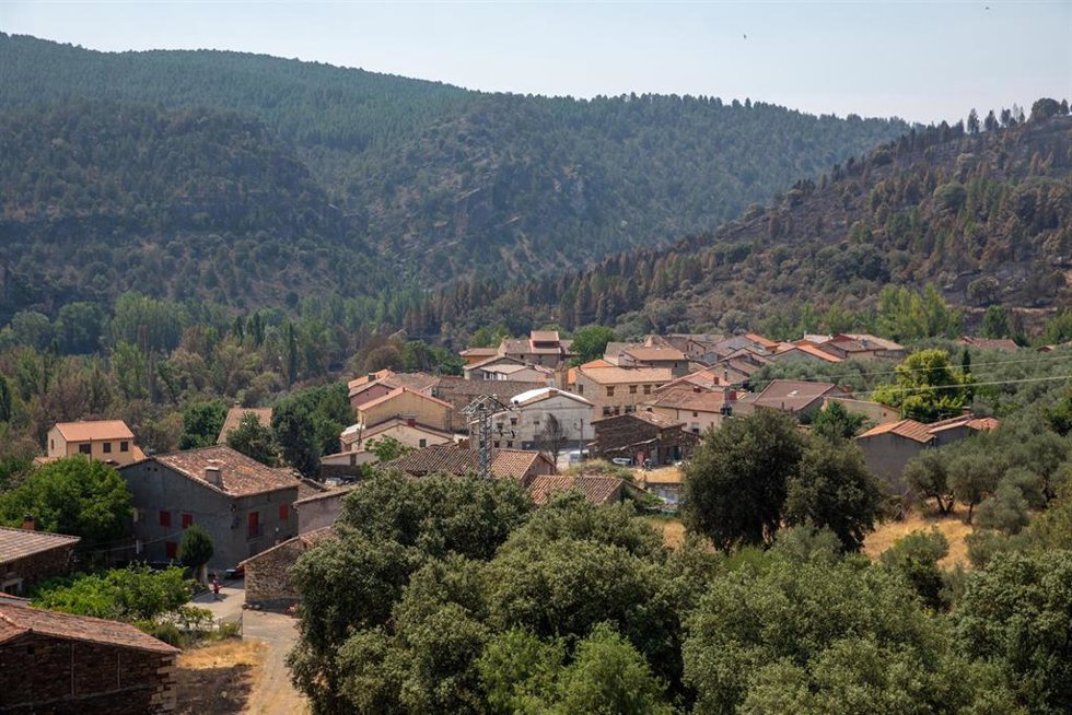 Vista del pueblo con el terreno quemado por el incendio forestal al fondo, a 23 de julio de 2026, en La Mierla, Guadalajara, Castilla-La Mancha (España). Según fuentes del gobierno regional, el fuego de La Mierla, que cumple su primera semana activo y que