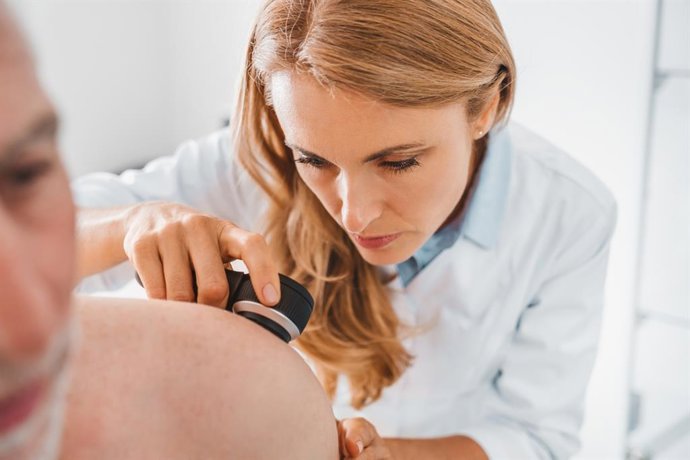 Archivo - Imagen de recurso de una dermatóloga examinando la piel de un paciente.