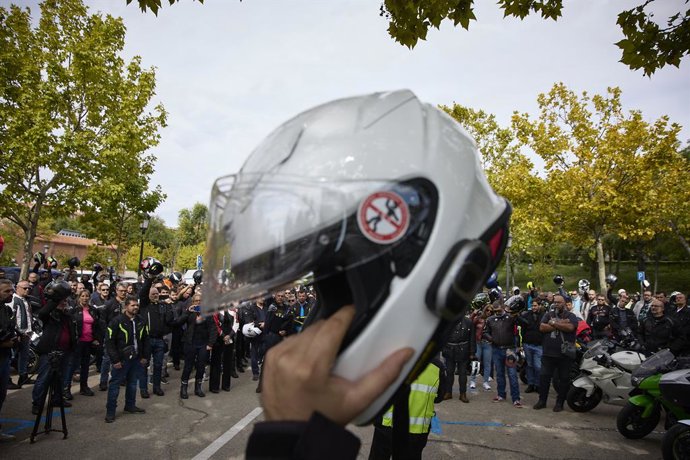Archivo - Un motorista levanta su casco