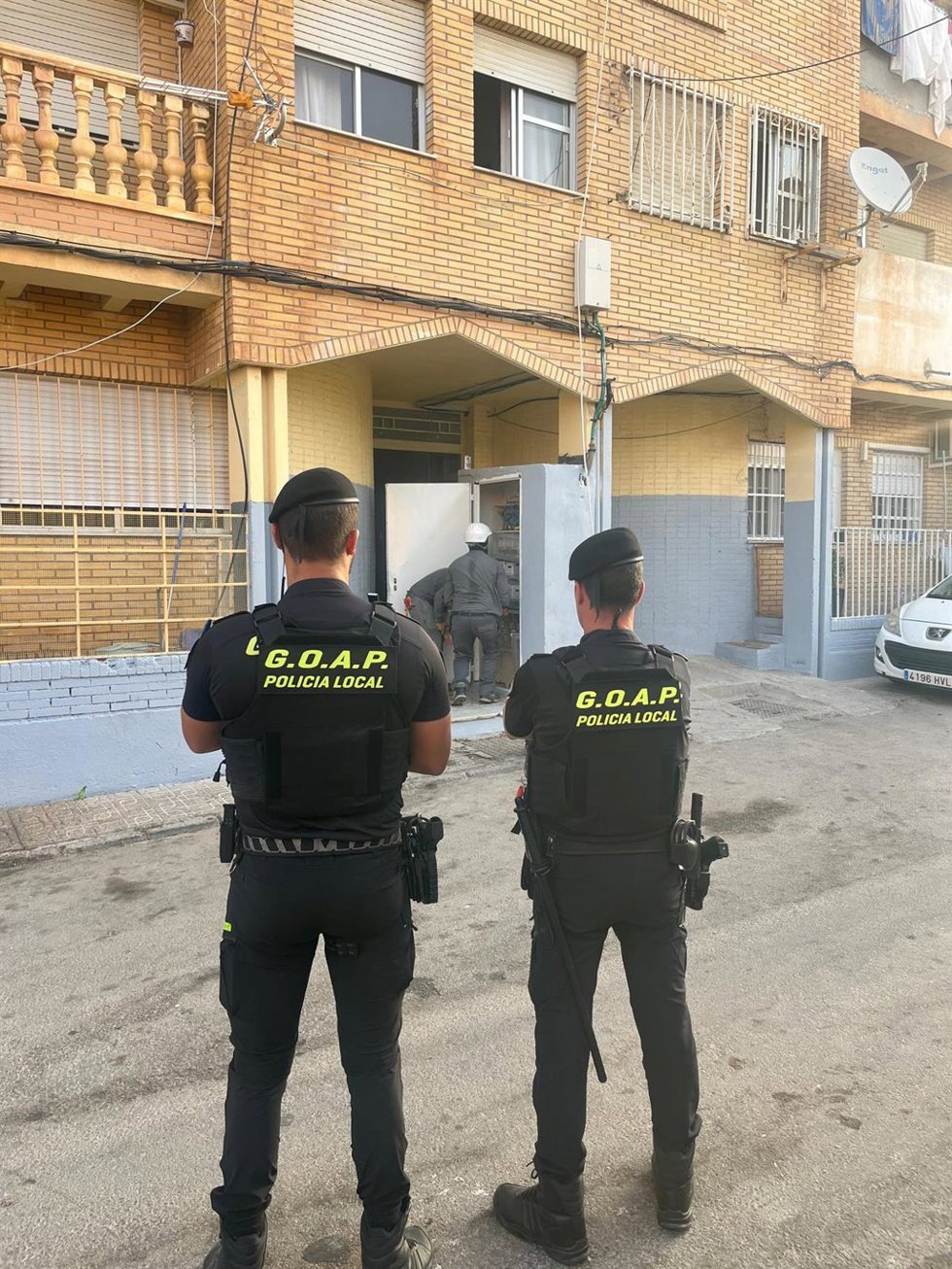 Agentes de la Policía Local de El Ejido (Almería) supervisan la retirada de enganches ilegales a la red eléctrica en el núcleo de Santa María del Águila.