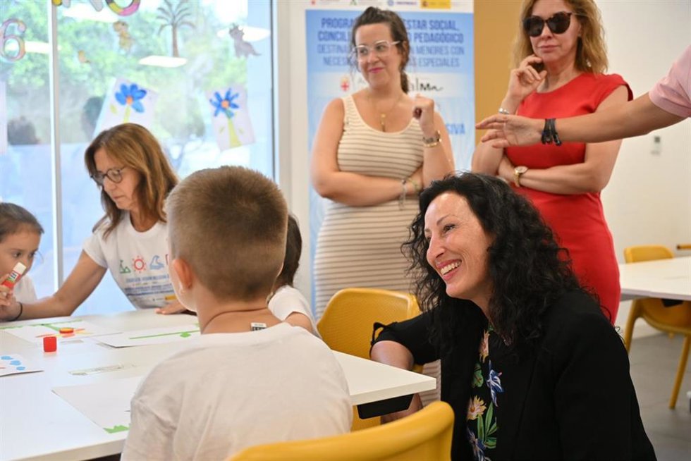 La alcaldesa de Almería, María del Mar Vázquez, conversa con uno de los menores durante su visita a las escuelas de verano del Espacio Alma.