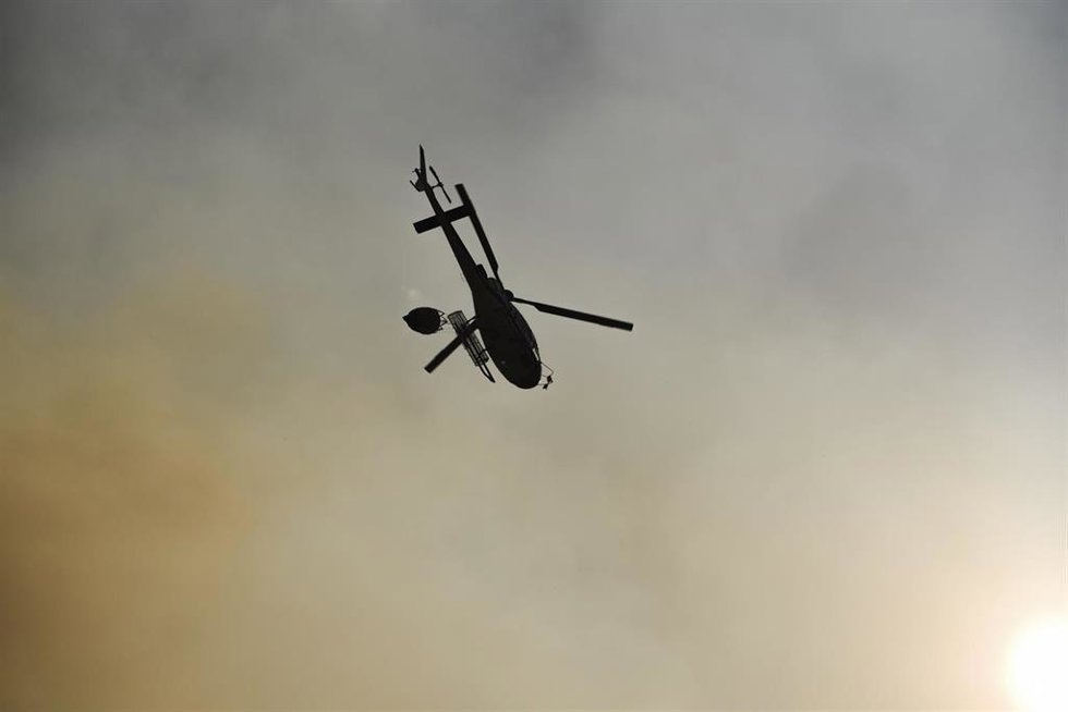 Un helicóptero trabaja en las labores de extinción,en Burgohondo, Ávila.