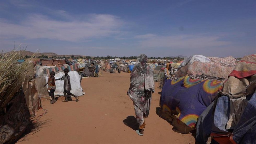 Archivo - Una mujer camina entre las tiendas de un campamento de desplazados cerca de la localidad fronteriza de Al Tina, en el oeste de Sudán