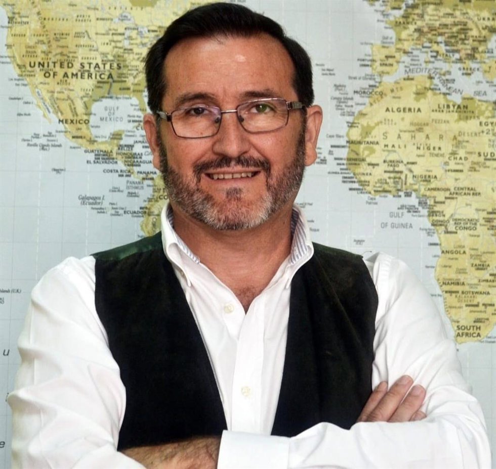 Manuel Pérez, profesor de Dos Hermanas, delante de un mapa mundi en una de las clases de su academia