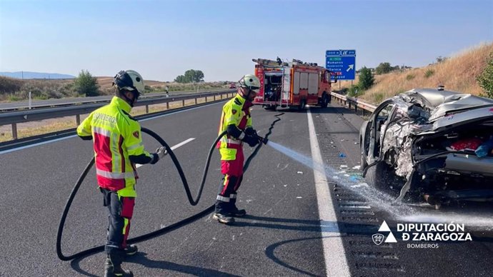 Bomberos de la DPZ aplican agua sobre el vehículo accdientado este sábado en la A-23.
