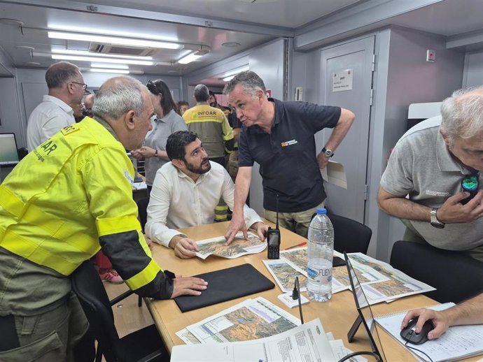 EL vicepresidente del Gobierno de Aragón, Alejandro Nolasco, sentado, y el consejero de Medio Ambiente y Turismo, Luis Biendicho, este sábado en la reunión del Puesto de Mando Avanzado del incendio de Ejulve conociendo las últimas novedades.
