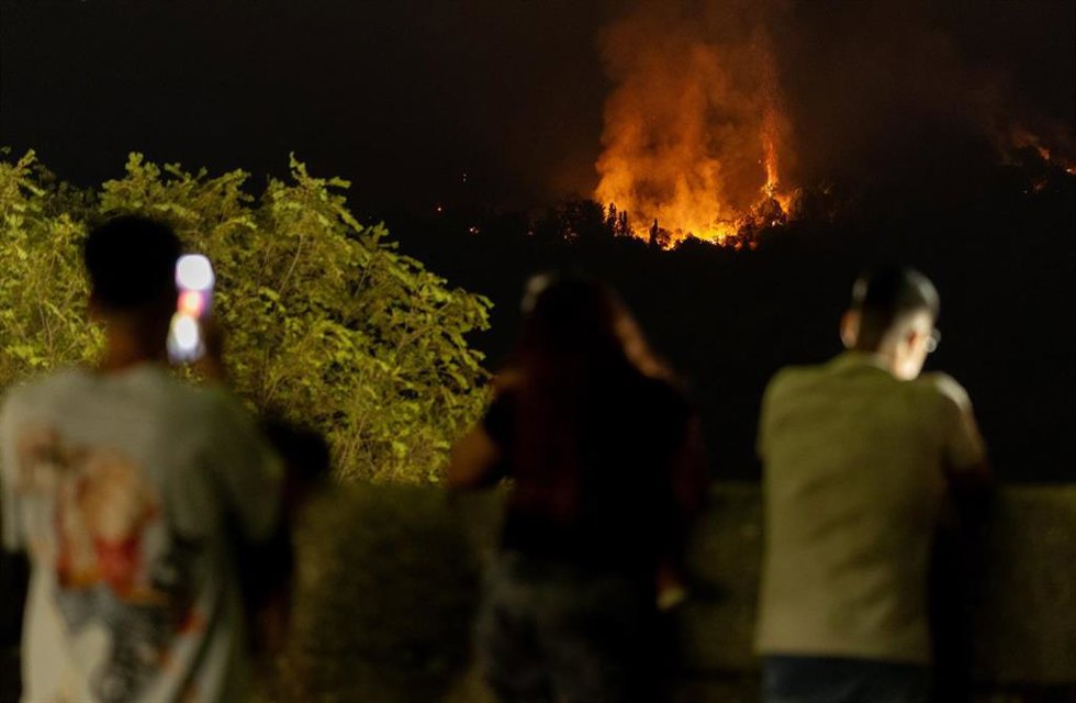 Varias personas observan el incendio, a 25 de julio de 2026, en San Martín de Valdeiglesias, Madrid (España). Durante la noche ha beneficiado el cambio de condiciones meteorológicas, con menos viento, mayor humedad y menos temperatura, aunque el fuego sig