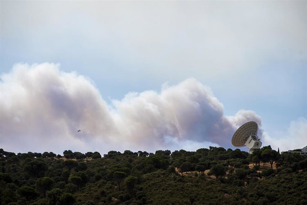 El humo de un fuego cercano sobrevuela una antena de la NASA, a 24 de julio de 2026, en Robledo de Chavela, Madrid (España). Los incendios que afectan a la Comunidad de Madrid siguen avanzando sin control y se han unido en un solo foco, mientras que en Áv