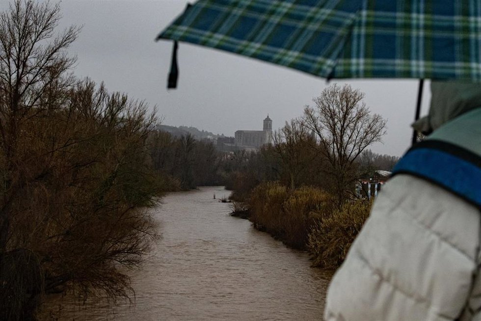 Archivo - Una persona observa la lluvia en el Río Ter en Girona