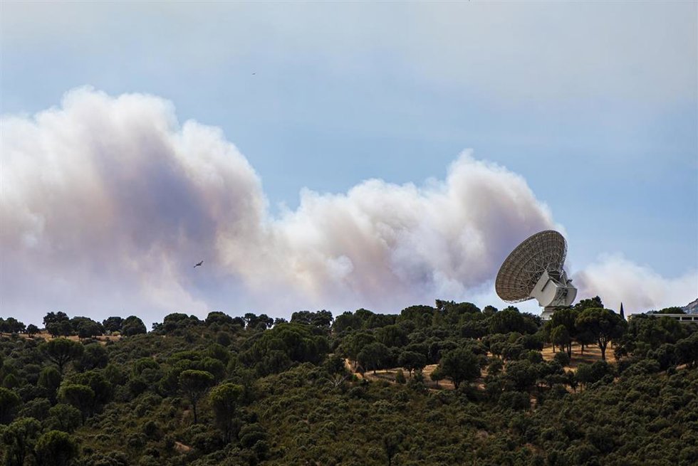 El humo de un fuego cercano sobrevuela una antena de la NASA, a 24 de julio de 2026, en Robledo de Chavela, Madrid (España). Los incendios que afectan a la Comunidad de Madrid siguen avanzando sin control y se han unido en un solo foco, mientras que en Áv