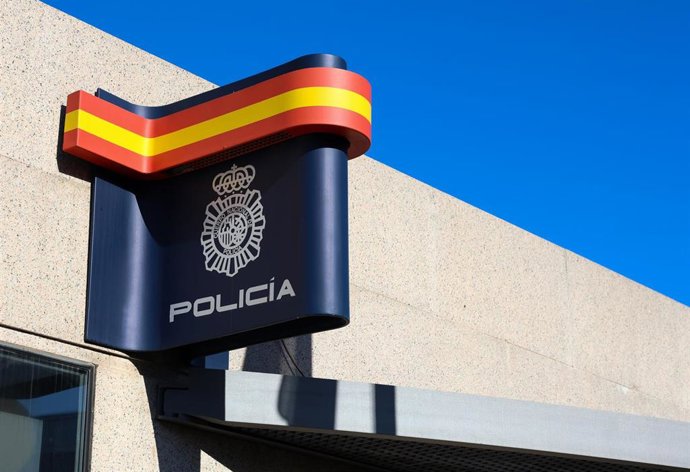 Archivo - Colores de la bandera de España envueltos en el logo de la policía en una comisaría 