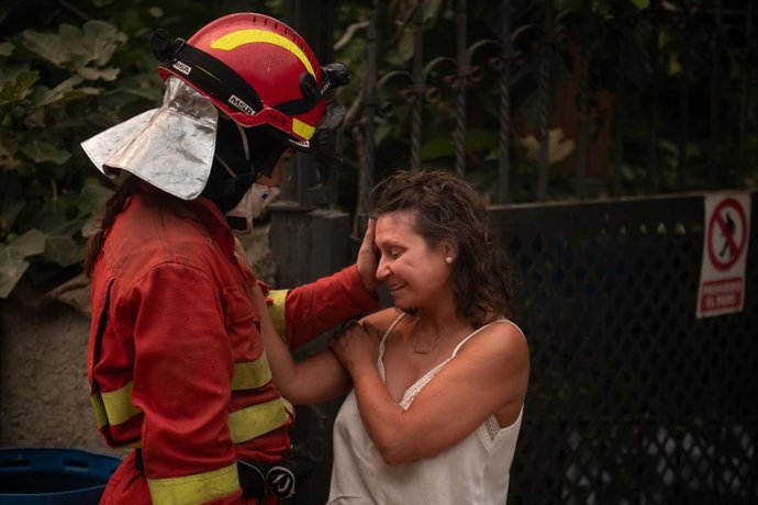 Una efectiu de l'UME consola a una veïna de Piedralaves després de cremar-se la casa del seu pare 