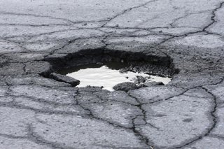 Archivo - Socavón en la carretera, bache