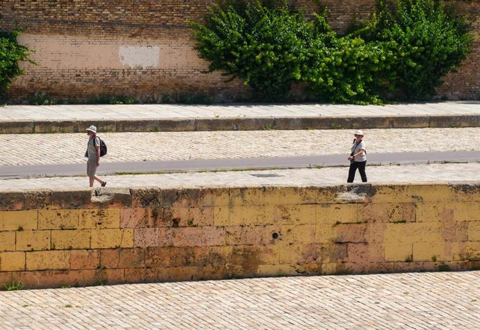 Archivo - Turistas con ropa veraniega en Sevilla.