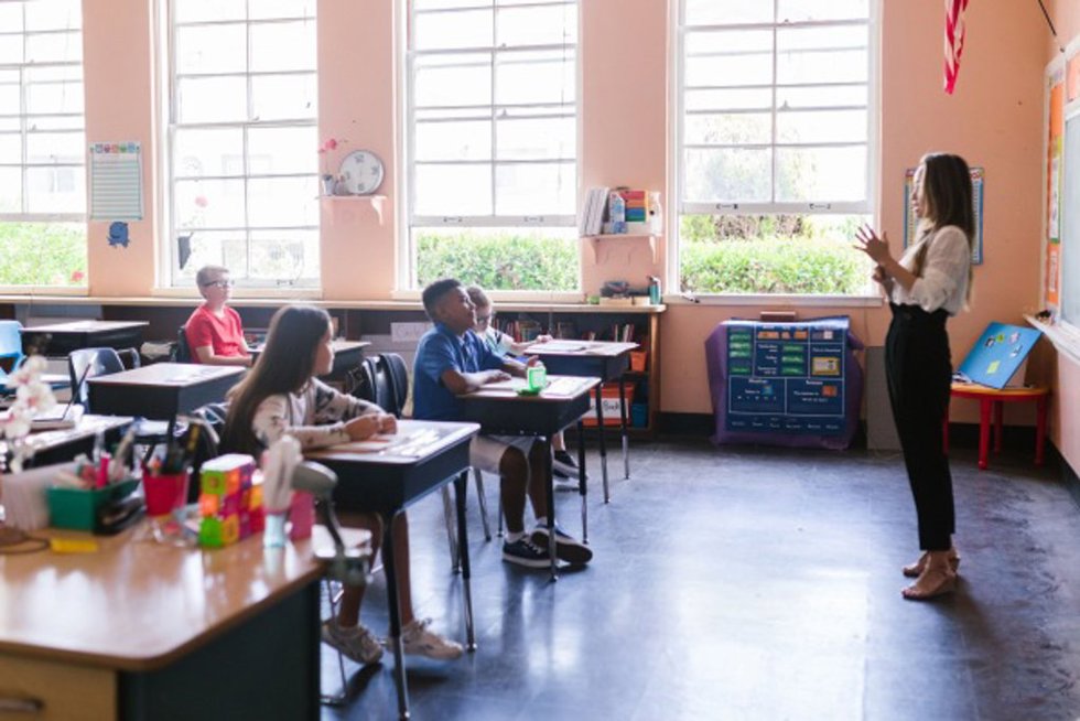 Una profesora da clase en un aula.