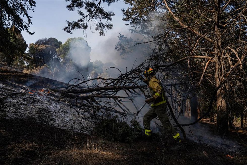 Un bombero trabaja en las tareas de extinción del incendio forestal en la Sierra Oeste de Madrid, en los alrededores del Pantano de San Juan, a 28 de julio de 2026, en Madrid (España).
