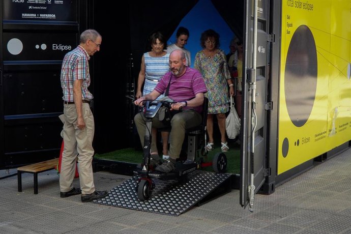 Una persona con discapacidad desciende de la cabina de simulación inmersiva de un eclipse total de Sol.