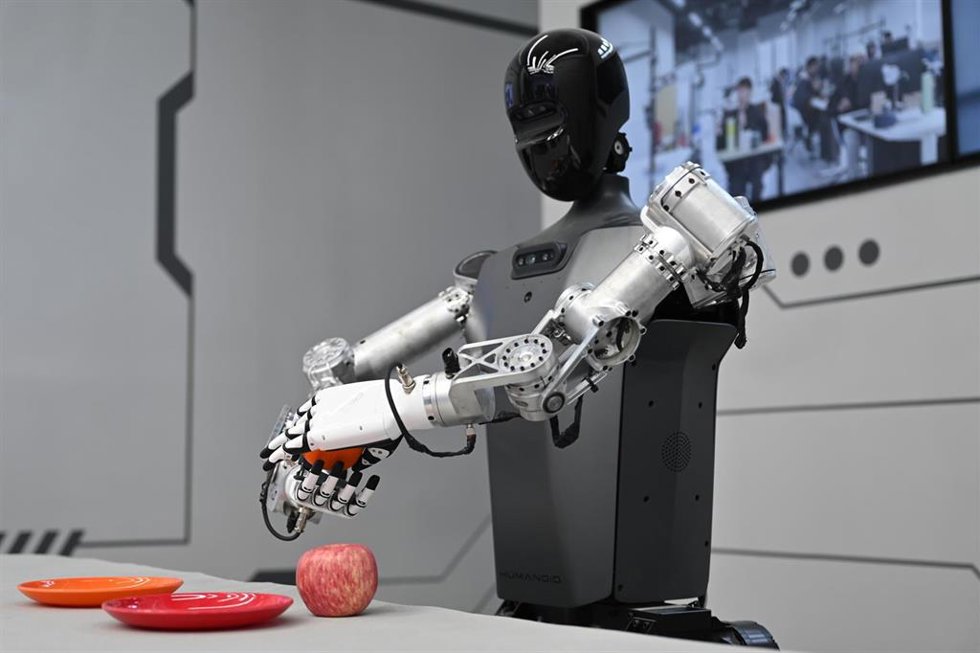 Archivo - FILED - 16 May 2025, China, Peking: A "Tiangong" robot holds an orange in its hands. Similar to movies, TV series, and TV ads where a beautiful girl is used to persuade consumers to buy something they don't need or want, a new study has revealed