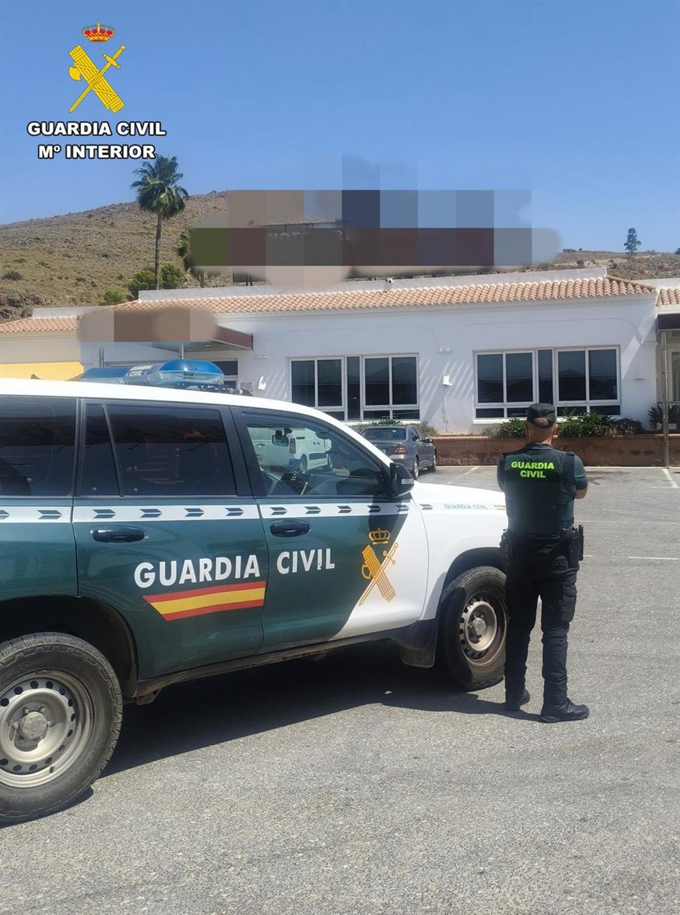 Un agente de la Guardia Civil junto a un vehículo oficial.